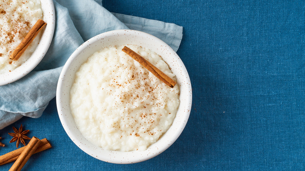rice pudding with ground and fresh cinnamon in a bowl