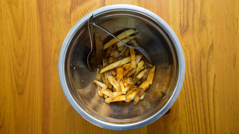 seasoned fries in mixing bowl