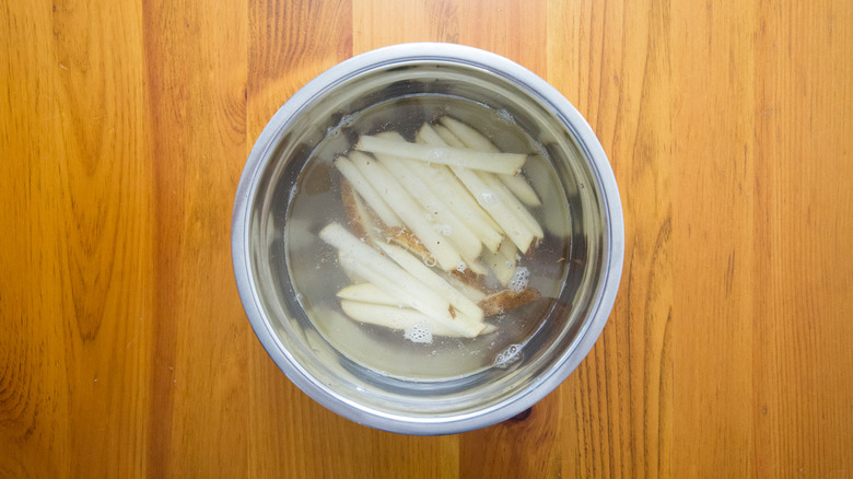 sliced potatoes soaking in bowl
