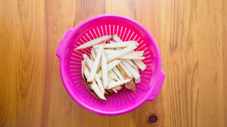 potato slices in pink colander