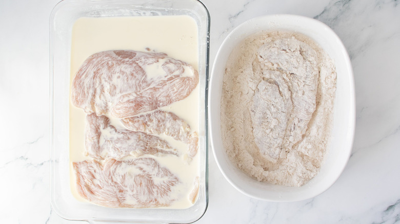 Chicken in buttermilk next to chicken breast in flour mixture