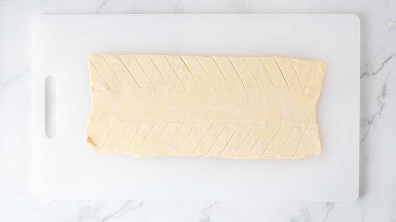 one rectangle of pastry dough with diagonal slits