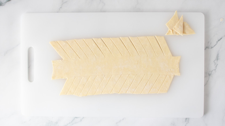 pastry dough with diagonal slits and a few pieces missing
