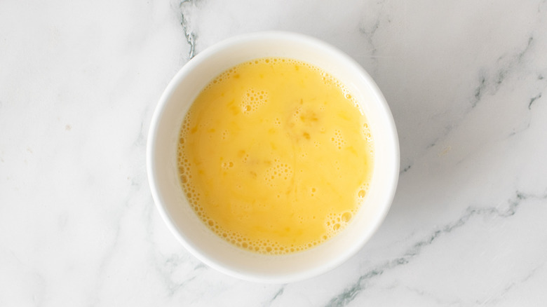 beaten egg in a white bowl