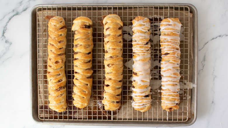 five glazed braided pastry sticks on a wire rack