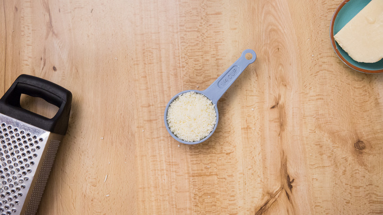 grated cheese in measuring cup