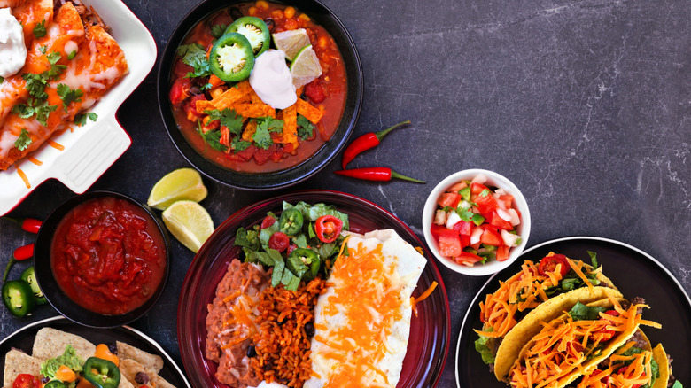 Spread of Mexican foods on black stone surface