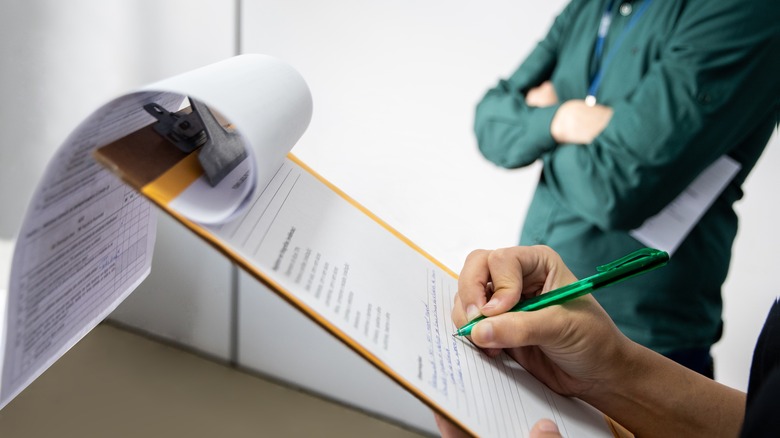 inspector writing on clipboard