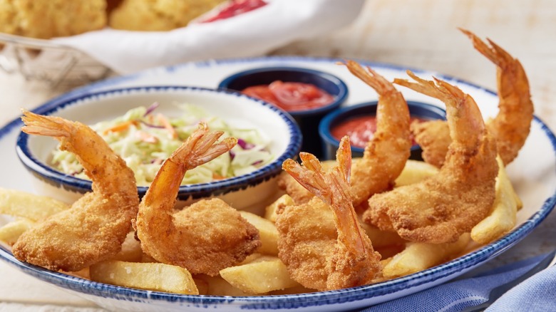 fried shrimp on a plate with coleslaw and sauce