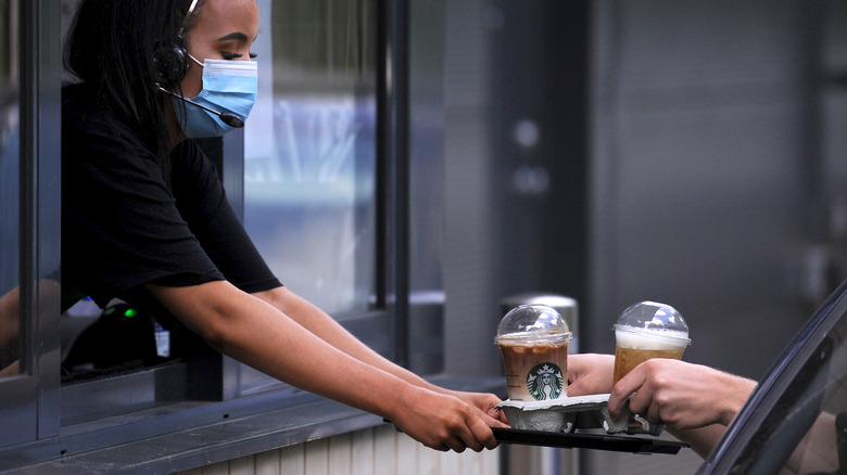 Starbucks barista giving customer coffee