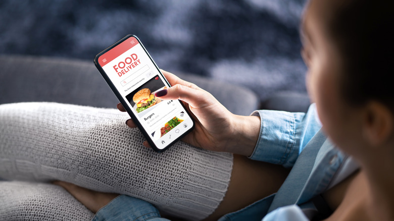 Woman using food delivery app on phone