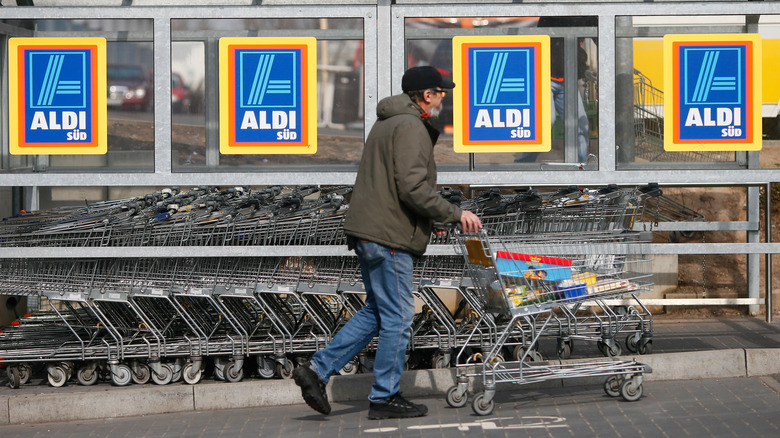 Person pushing Aldi shopping cart