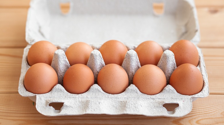 An open carton of a dozen eggs