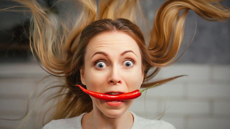 Woman with pepper in mouth