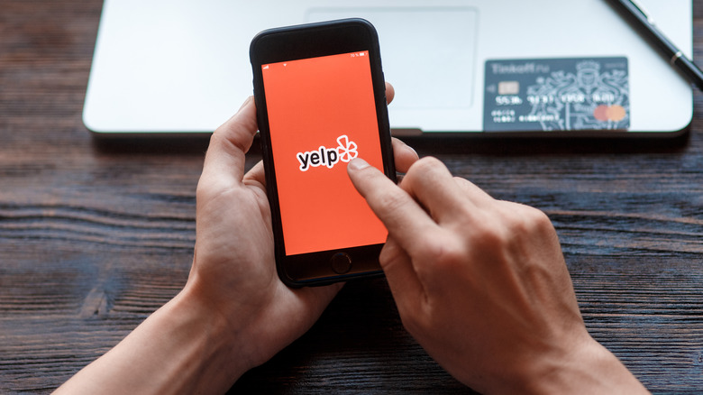 A woman using Yelp on her phone