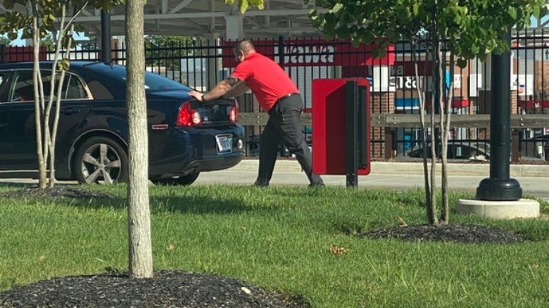 chick-fil-a employee pushing car through drive-thru