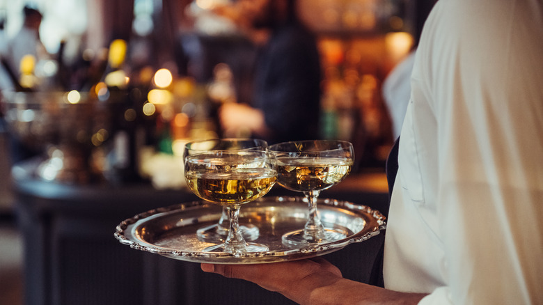 Waiter carrying tray of drinks