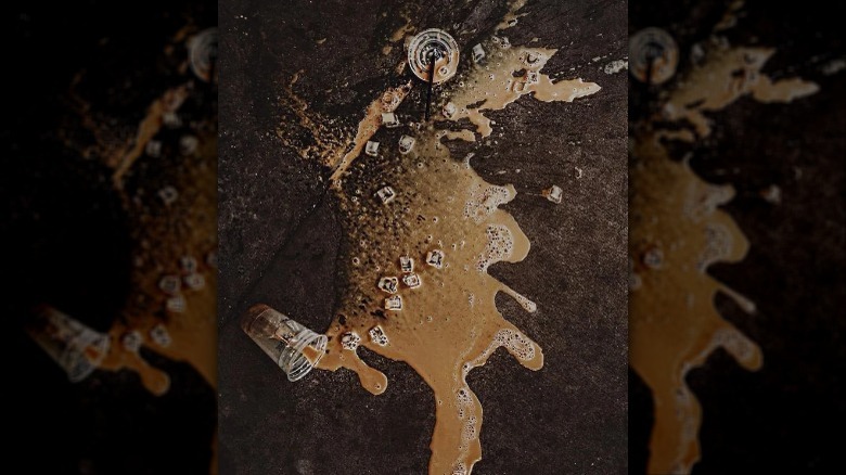 iced coffee spilled on black asphalt 