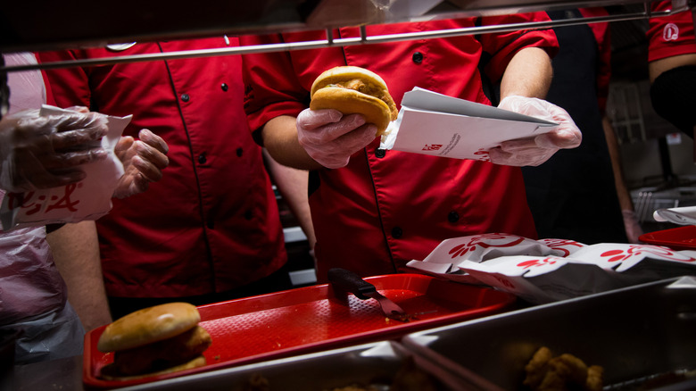 Chick-fil-A workers stuffing burgers