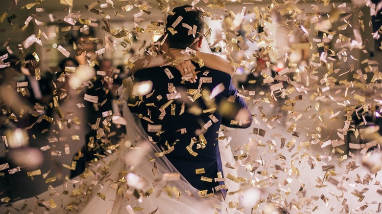 Bride and groom standing with confetti