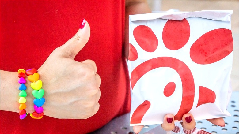 Chick-fil-A sandwich bag and thumbs up hand with rainbow bracelet