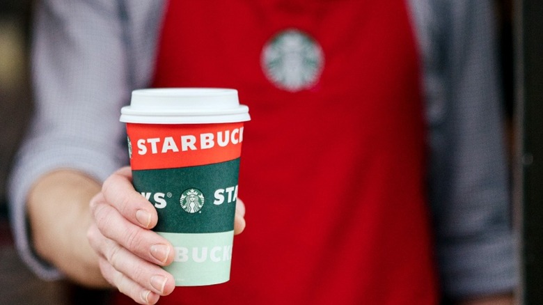 barista holding Starbucks cup