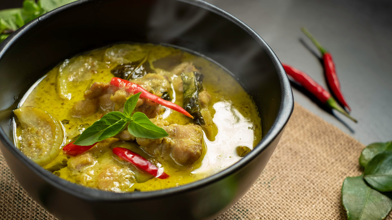 Green curry in a black bowl