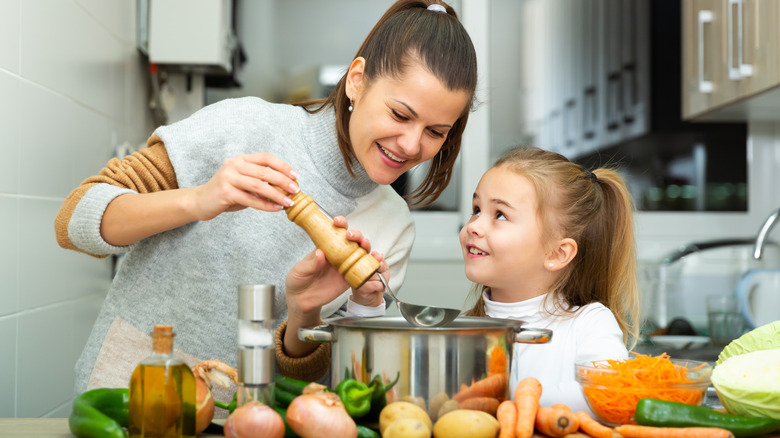 Mother and daughter making soup together