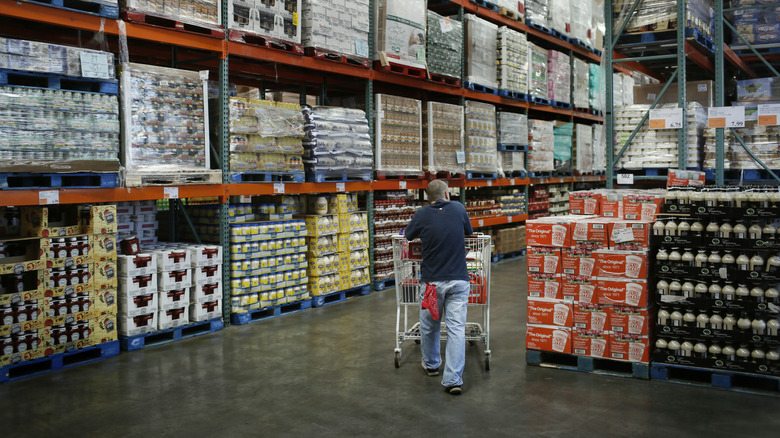 man pushing cart through Costco aisle