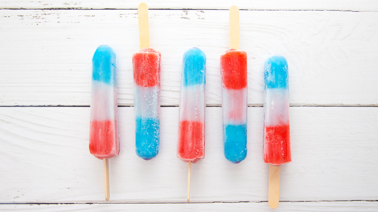 Red, white, and blue popsicles on a wooden table