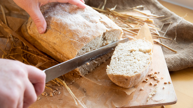 Person slicing bread loaf
