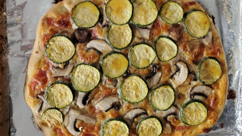 Pizza topped with zucchini and mushrooms