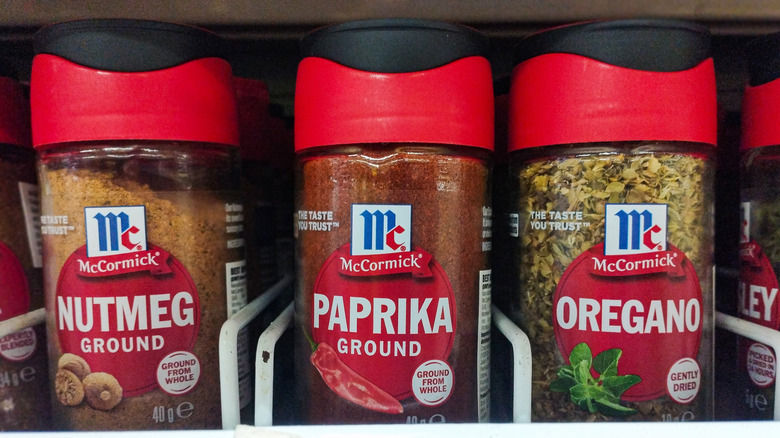 Bottles of McCormick spices on a shelf: nutmeg, paprika, oregano