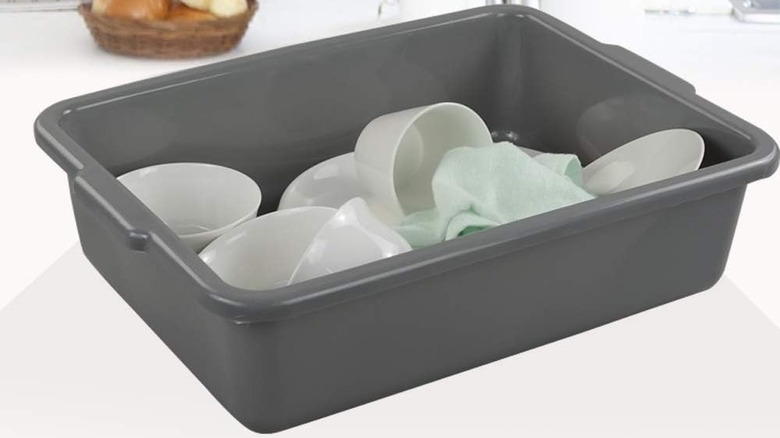 Gray bus bin filled with dishes