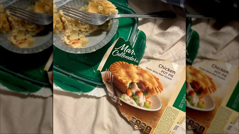 Torn package and partially eaten, heated Marie Callendar's Chicken Pot Pie with a fork in it