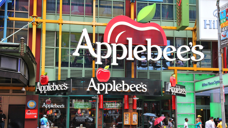 Pedestrians pass by an Applebee's.