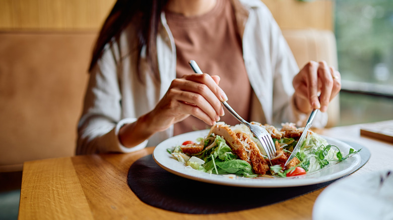 Woman dines on a salad at a restaurant.