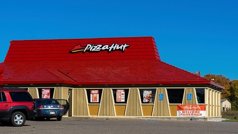 Cars park outside a Pizza Hut.