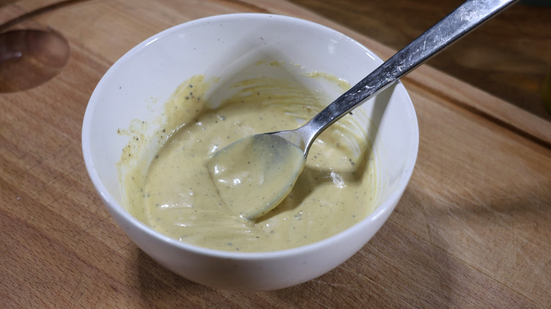 bowl of creamy Dijonnaise sauce with spoon in it