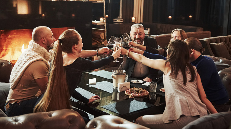 Group of adult at a restaurant making a toast with wine