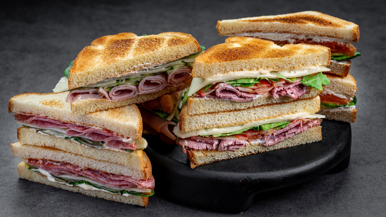 Assorted sandwiches with deli meat and condiments.