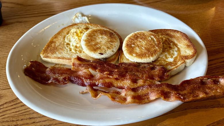 toast, eggs, bacon on plate on table at Cracker Barrel