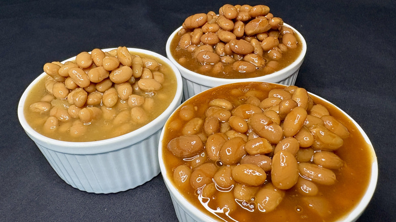 Three white dishes filled with baked beans