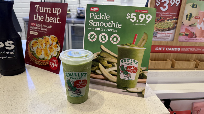 Smoothie King x Grillo's Pickles Smoothie in a plastic to-go cup and sign