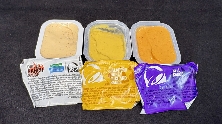 Three Taco Bell dipping sauces on a black background