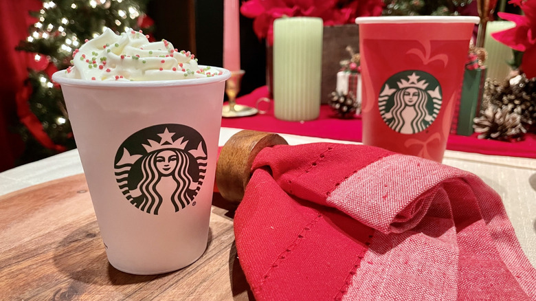 Two Starbucks cups with 2025 holiday menu drinks