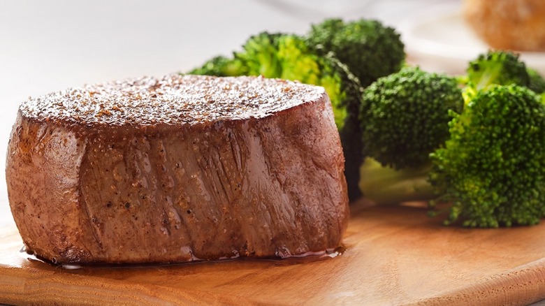 Close up for filet mignon with broccoli in the background