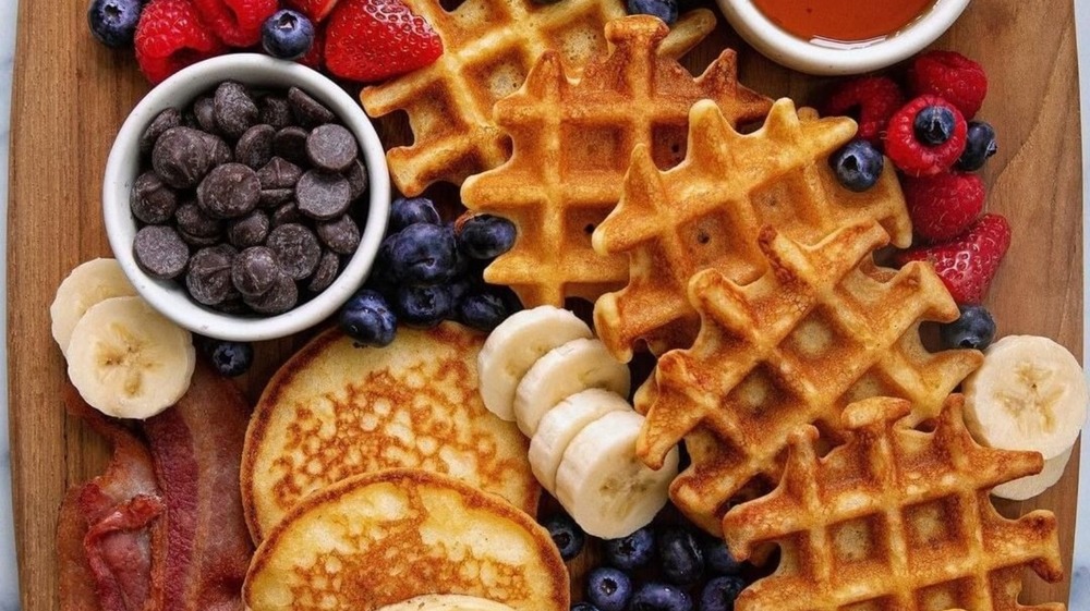 Breakfast charcuterie board with pancakes, waffles, and more