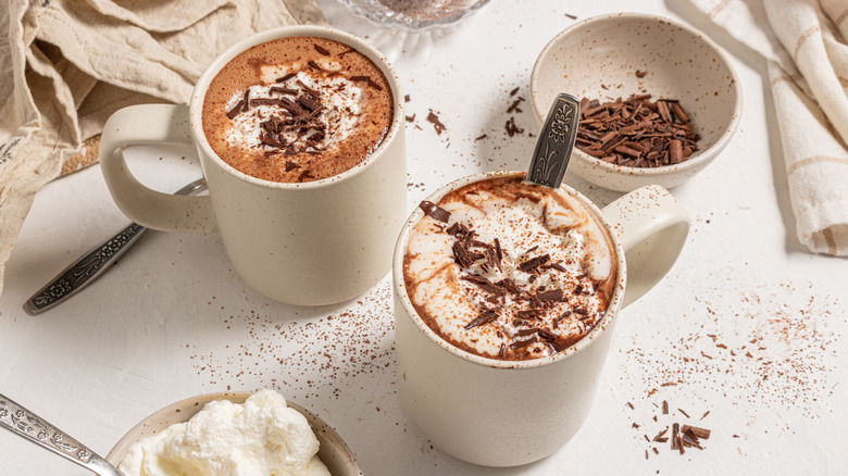 Two cups with espresso hot chocolate, whipped cream, and shaved chocolate on top