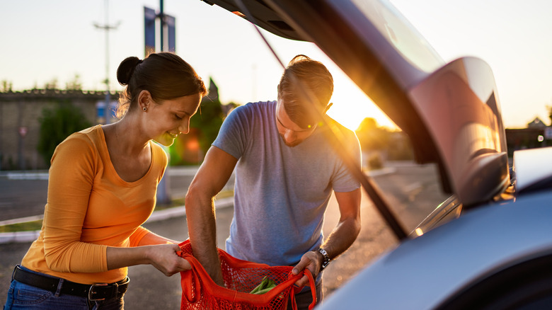 couple putting groceries in car